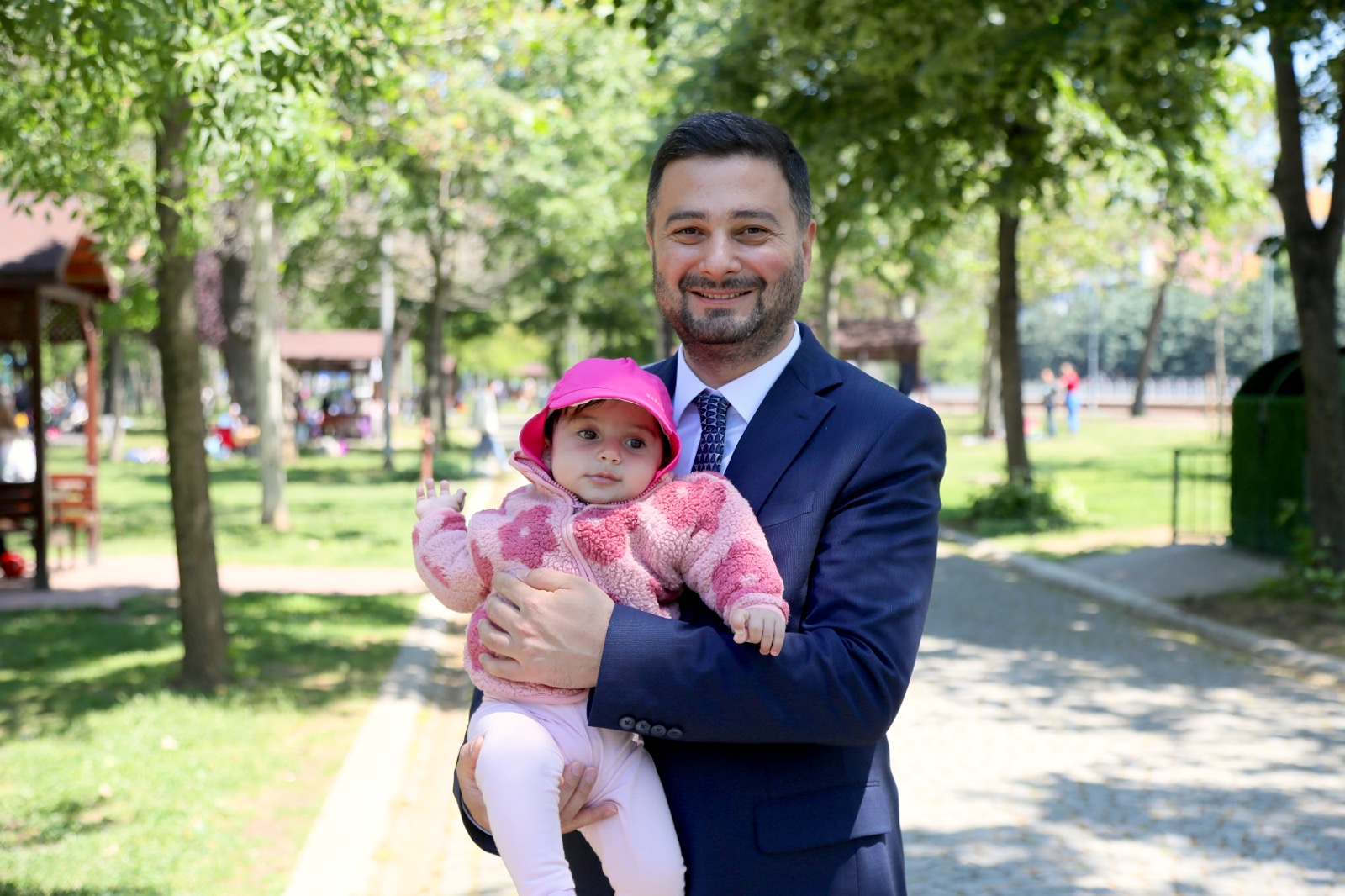 Mevlüt Öztekin parkta bir bebeği kucağında tutuyor.