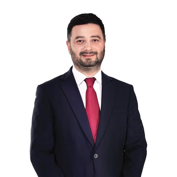 Kâğıthane Belediye Başkanı Mevlüt Öztekin’in resmî portresi: lacivert takım elbise, kırmızı kravat, beyaz zemin.