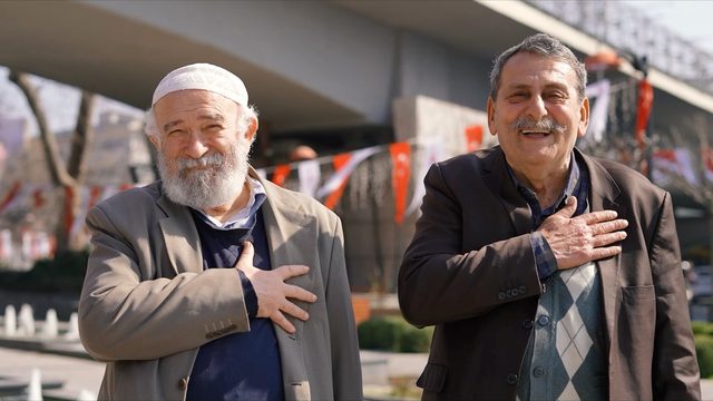 İki yaşlı hemşehrimiz, elleri kalplerinin üstünde.